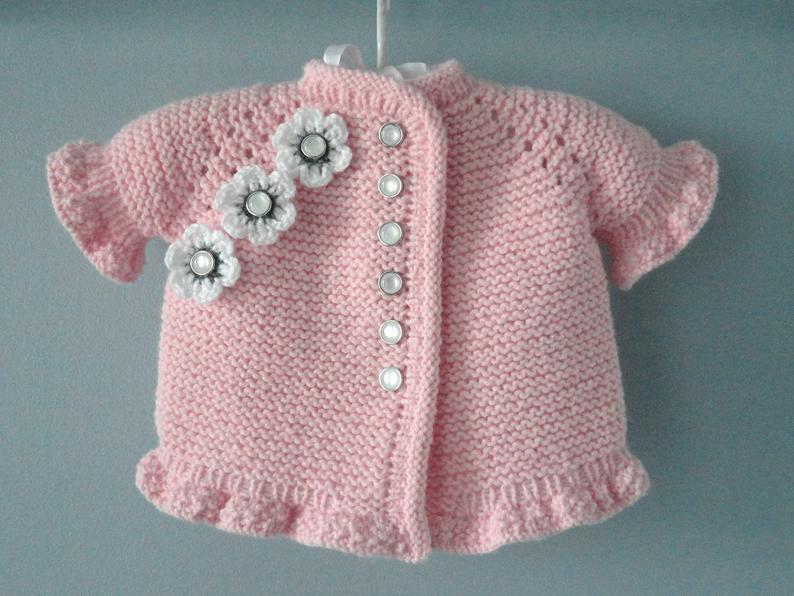 Crochet baby girl pink cardigan with ruffle hem and flowers