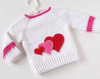 Crochet white baby sweater with red and pink hearts