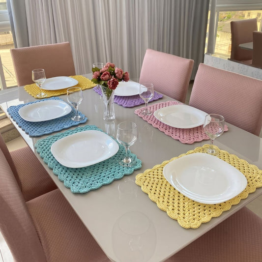 Set of 6 crochet pastel placemats laid out on a dining table