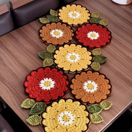 Crochet table runner with a rose-inspired pattern, laid out on a table