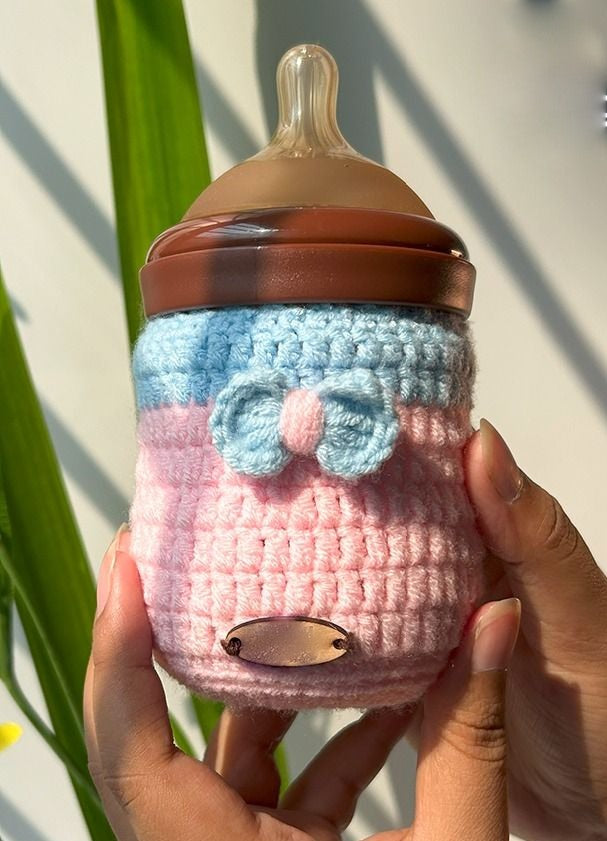 Handmade crochet teddy bear feeder cover with ears on a baby bottle
