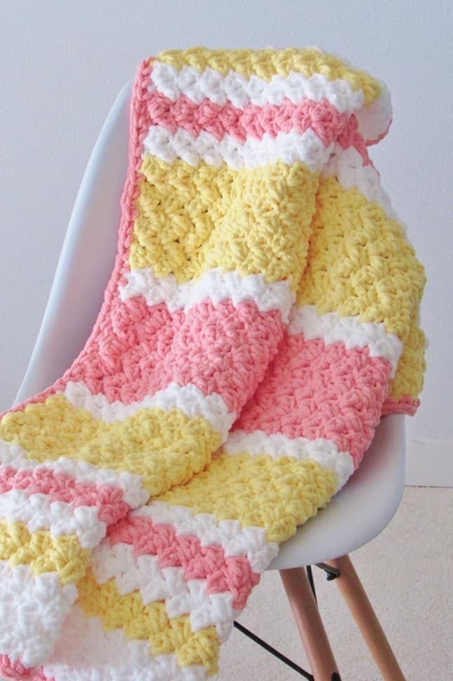Crochet baby blanket in pink, yellow and white stripes