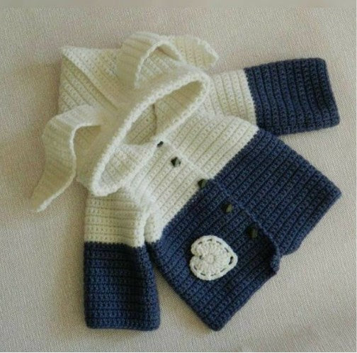 Handmade crochet baby boy hooded cardigan in navy blue and cream with flower detail