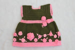 Handmade crochet baby girl green dress with pink floral applique and leaf detail