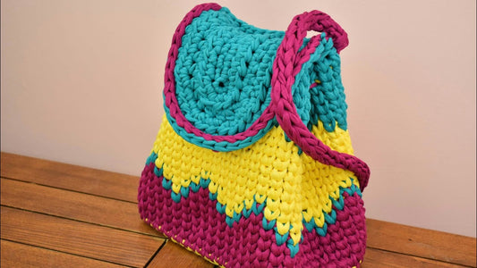 Crochet baby backpack in colourful teal, yellow and pink