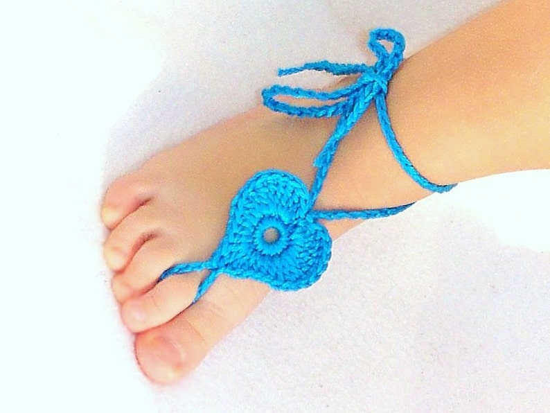 Blue crochet barefoot heart sandals with ankle ties on baby feet