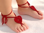 Red crochet barefoot heart sandals with ankle ties on baby feet