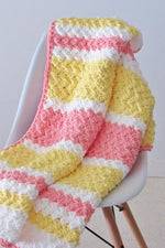 Handmade crochet baby blanket in pink, yellow and white stripes