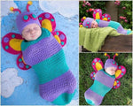 Newborn baby wrapped in a handmade crochet butterfly cocoon and hat set in purple and teal