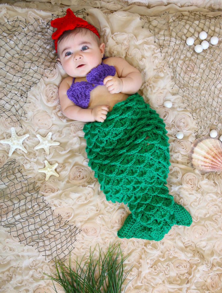 Baby girl in a handmade crochet mermaid tail cocoon set in green and purple with a red headband